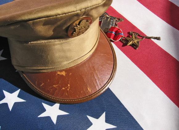 Military cap placed respectfully on an American flag