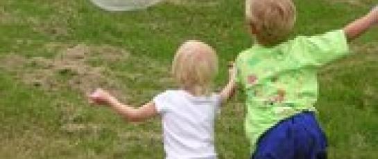Children playing in the park with bubbles