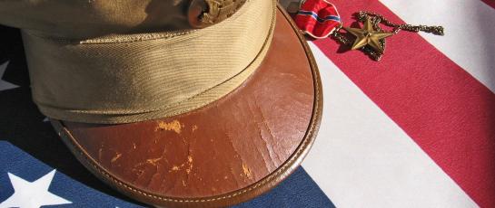 Military cap placed respectfully on an American flag