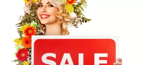 Lady with flower headdress holding "sale" sign