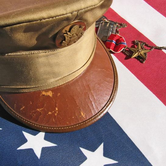 Military cap placed respectfully on an American flag