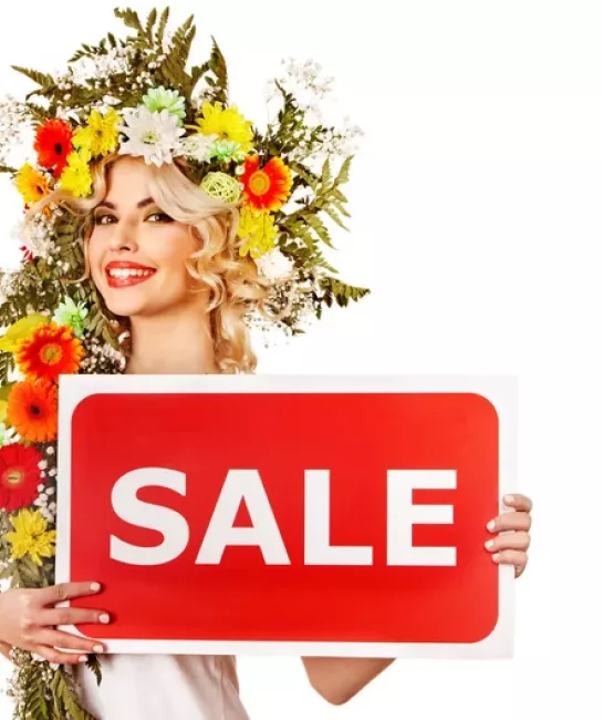 Lady with flower headdress holding "sale" sign