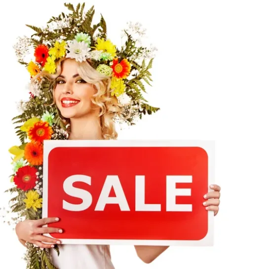 Lady with flower headdress holding "sale" sign