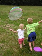 Children playing in the park with bubbles