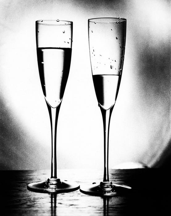 two champagne flutes against a silvery gray background