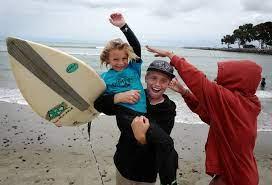 Kids with surfboard playing on the beach